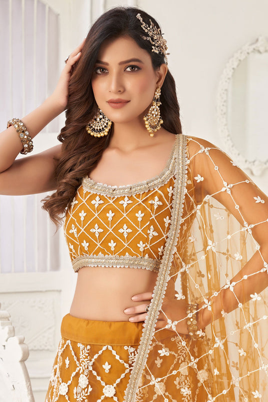 Net Wedding Wear Lehenga Choli In Mustard With Embroidery Work